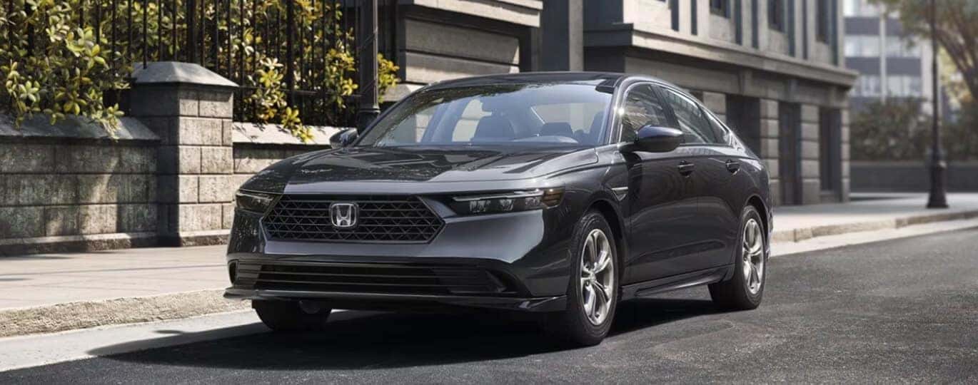 Front three-quarter view of a gray Honda Accord parked on a city street.