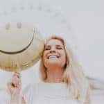 Happy BMW of Escondido customer holding a smiley-face balloon.