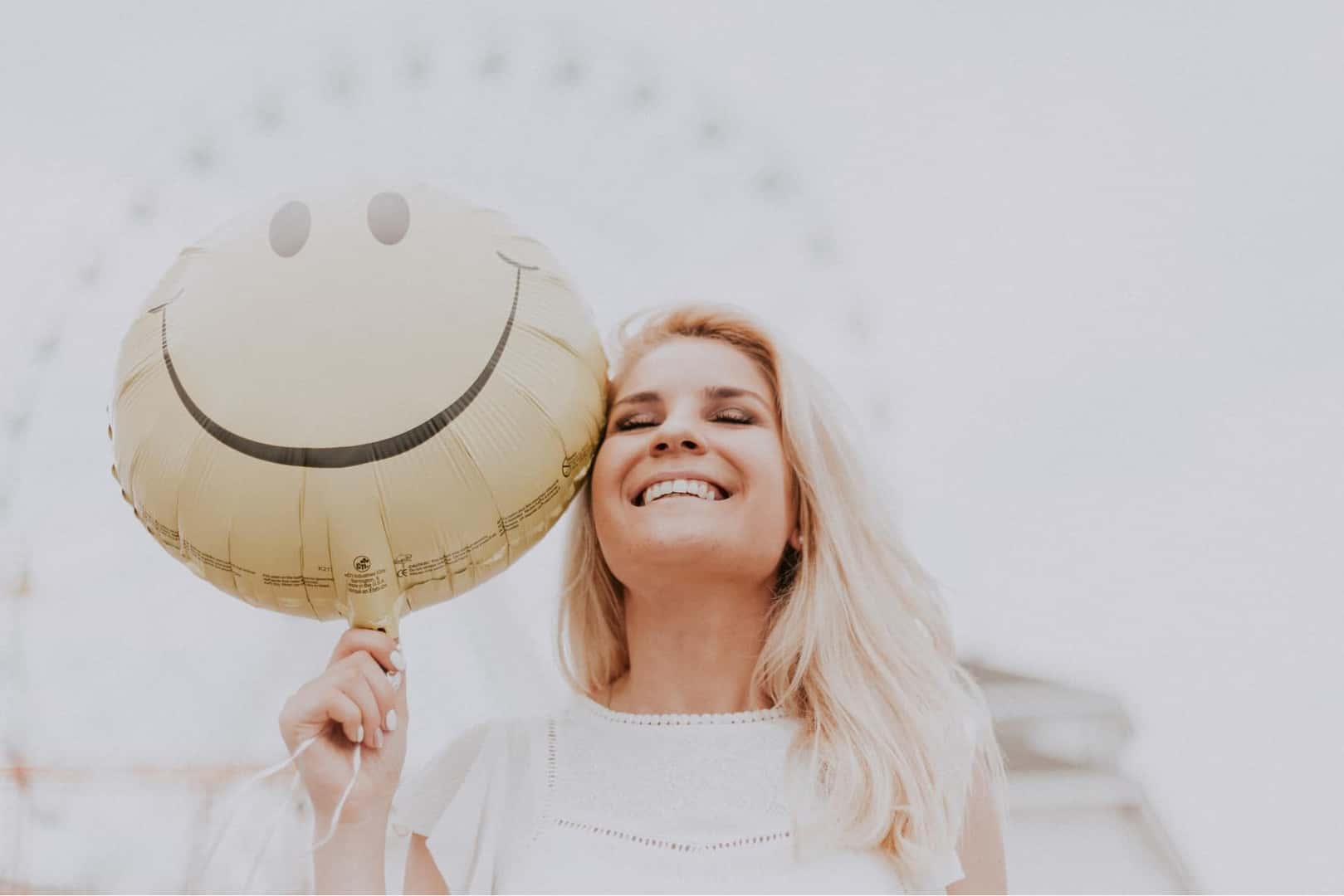 Happy BMW of Escondido customer holding a smiley-face balloon.