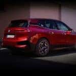 The new BMW iX All Electric SAV in Red with Woman Walking