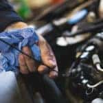 Mechanic checking oil on car
