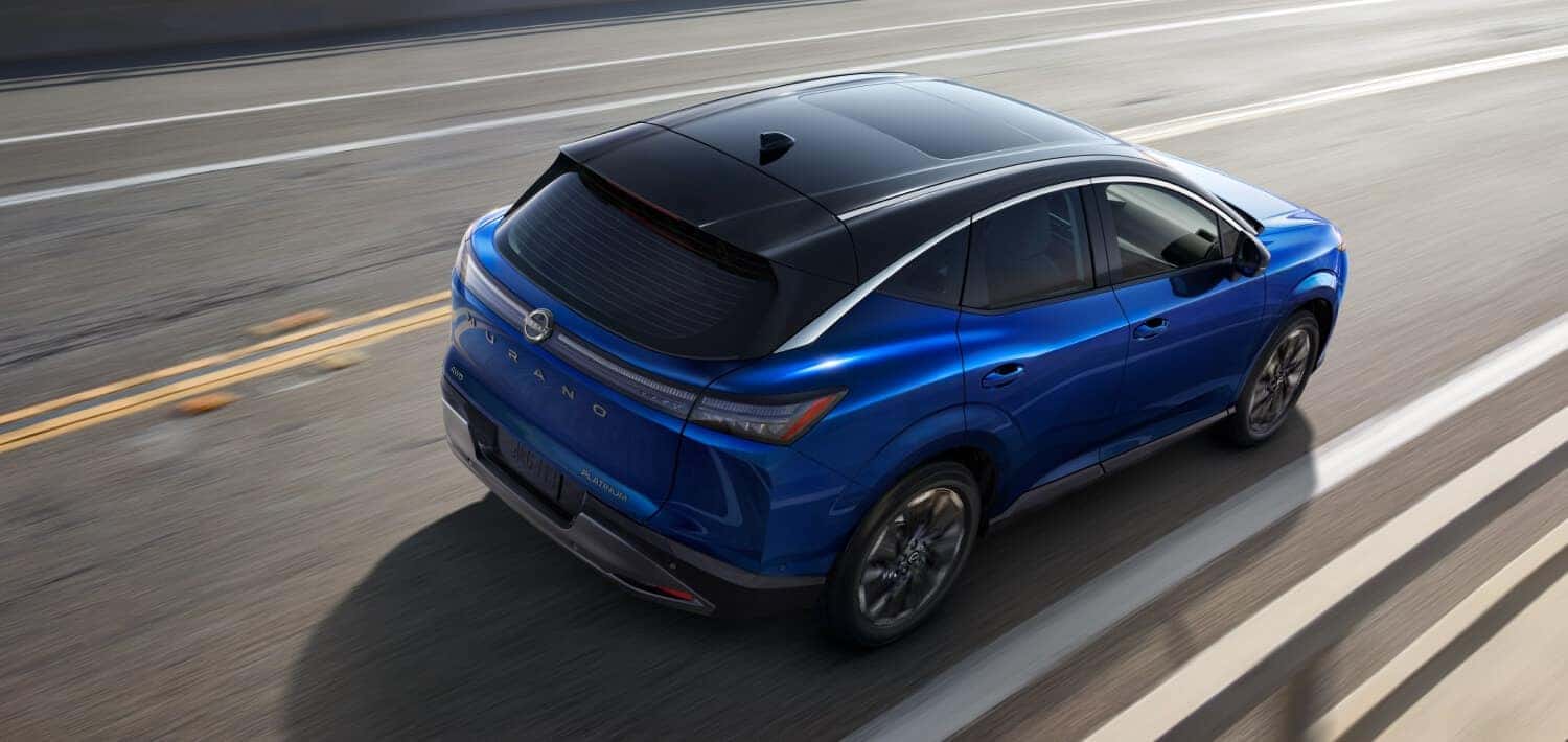 A rear shot of a blue 2025 Nissan Murano driving down the road