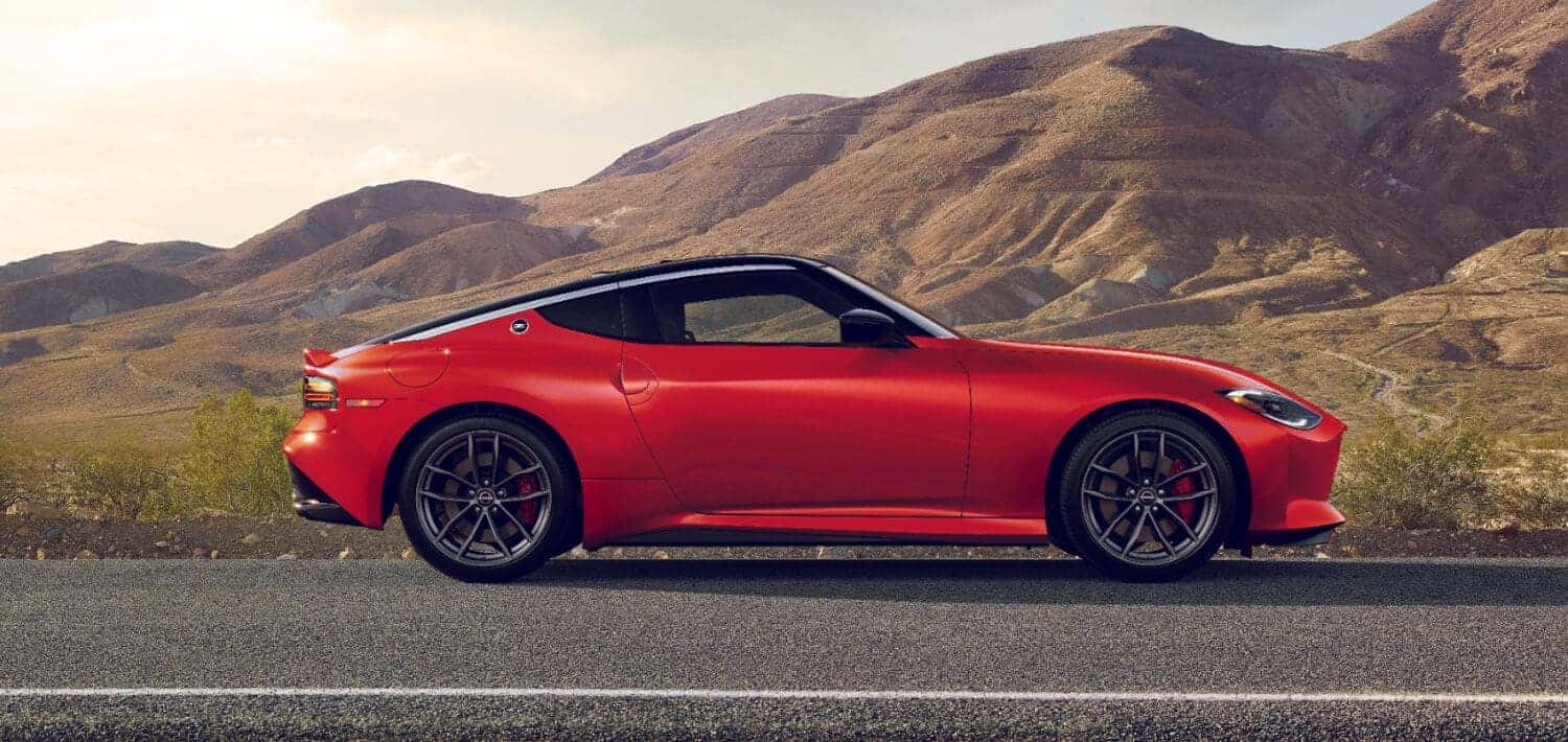 A red 2025 Nissan Z in profile against a hilly, desert background