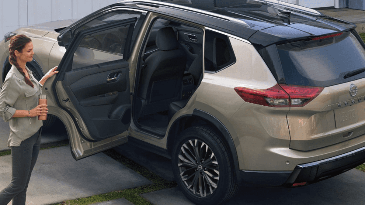 A family getting into a light-colored Nissan Rogue