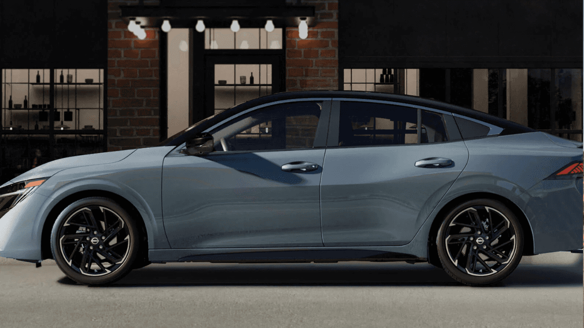 A grayish blue Nissan Sentra in profile, parked at a curb