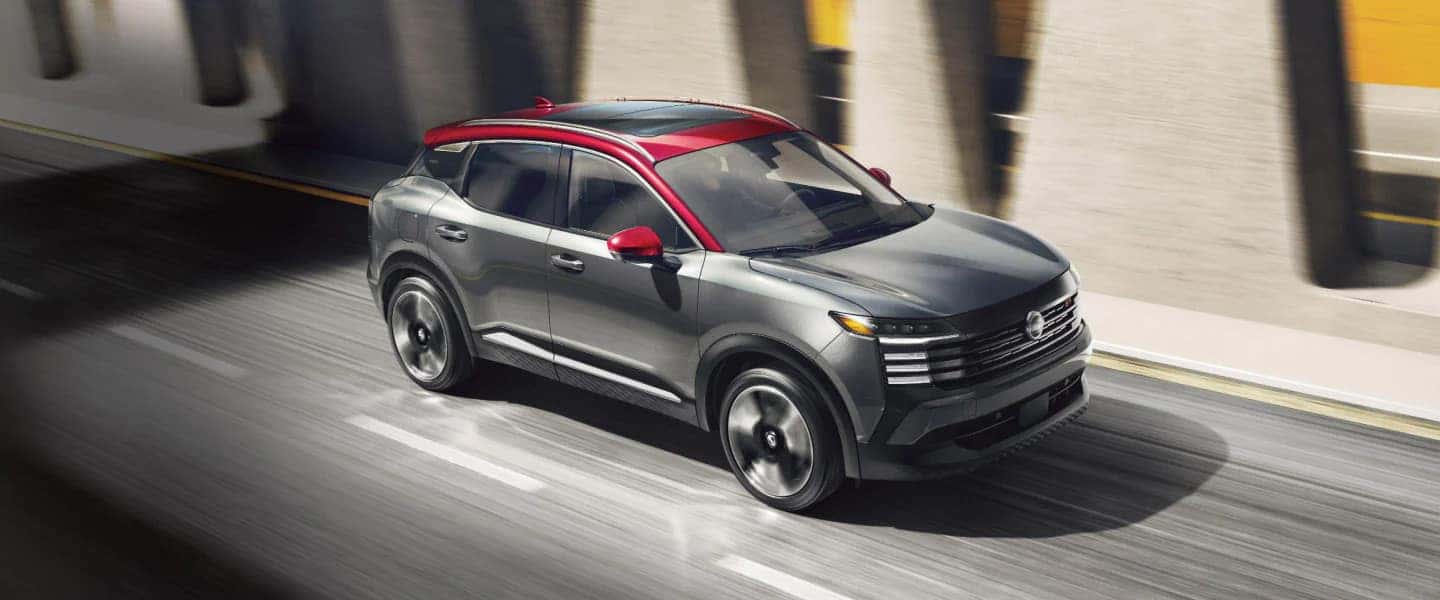 A gray Nissan Kicks with a red roof driving on the road