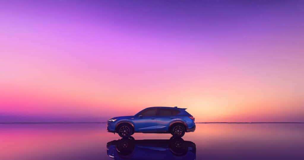 2025 Acura ADX side profile at sunset parked in shallow water with perfect reflection