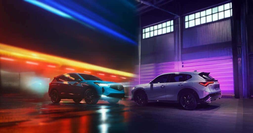 2025 Acura RDX and ADX parked outside of lit up industrial buildings