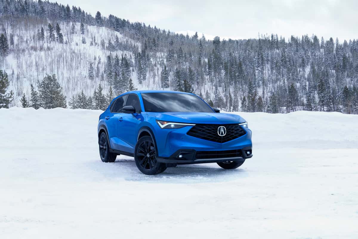 2026 Acura RDX in Double Apex Blue Pearl parked in a snowy mountain scene