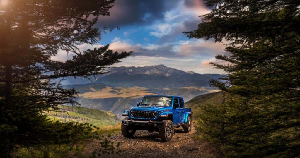 2025 Jeep Gladiator in blue parked on mountain trail with range in background