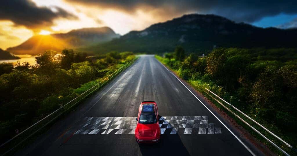 2025-Dodge-Charger-Daytona-EV-on-a-straight-road-in-the-mountains-with-a-checkered-line-on-the-road