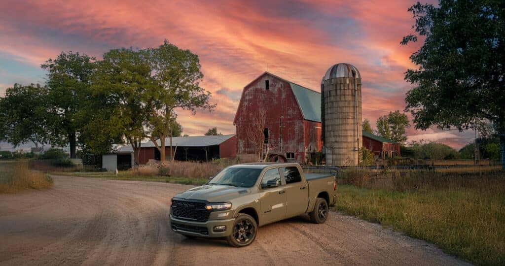 2026 RAM 1500 trim levels parked infront of an old farmstead with a red barn