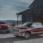 A pair of red 2019 RAM 1500 next to a barn in Ennis TX