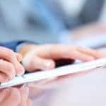 Close up of a man's hand singing financial documents