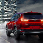 Red 2019 Honda CR-V driving at night in big city