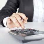 woman typing on calculator