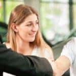 Couple handshaking businessman
