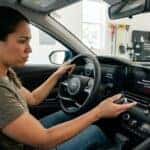 Worried Hyundai driver looks at a legible Battery Discharge Warning