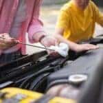 person checking engine fluids