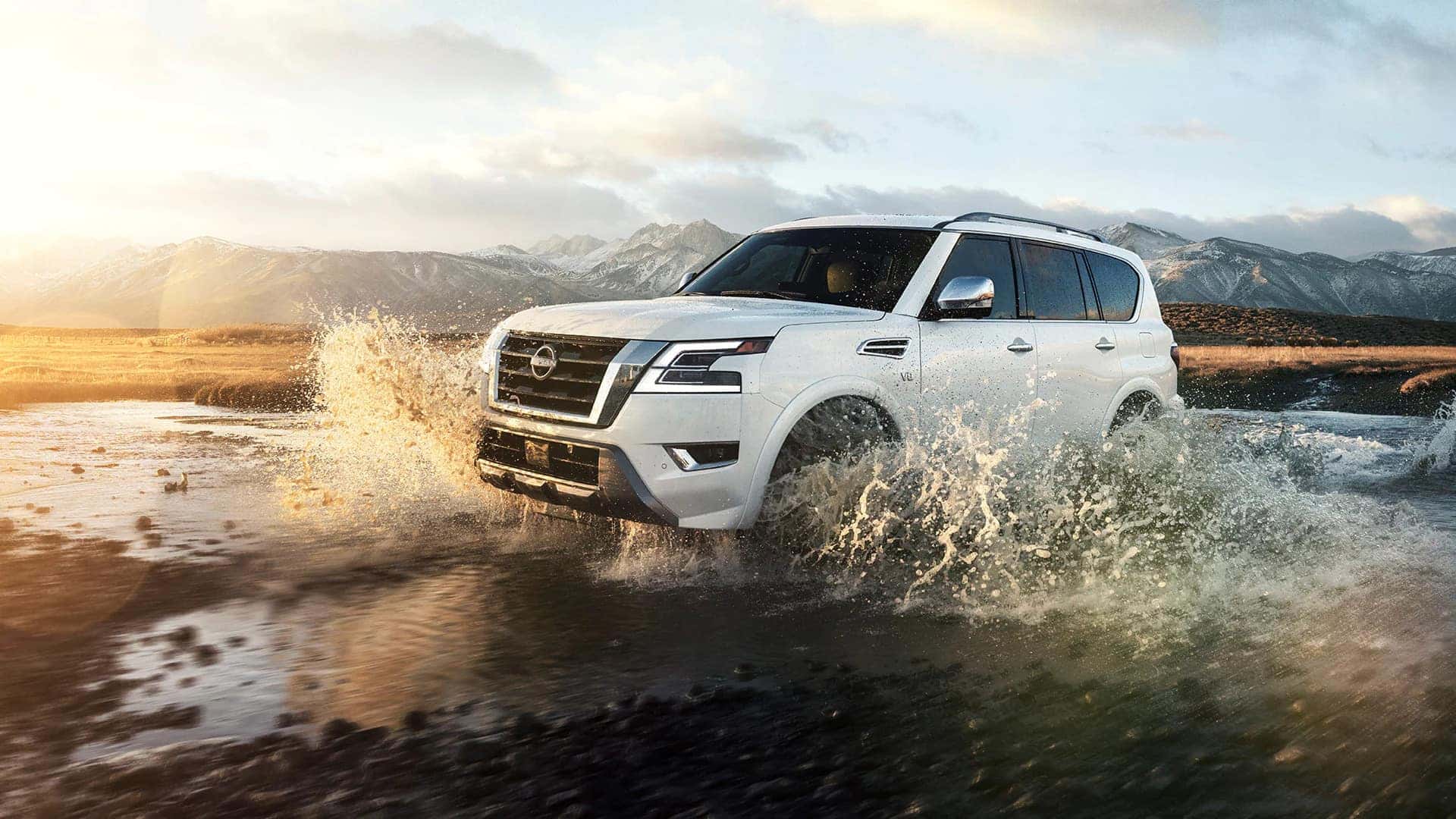 white nissan armada driving through large puddle