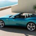 Blue Ferrari Amalfi Spider parked at a home by the ocean