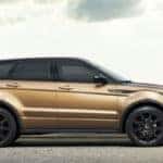 2019 Range Rover Evoque side view in gold parked in a city next to a river