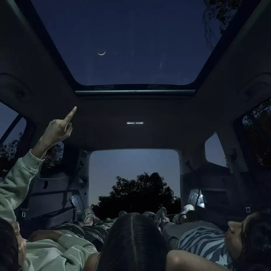 2026 Volkswagen Atlas interior showing panoramic sunroof at night with passengers viewing the sky