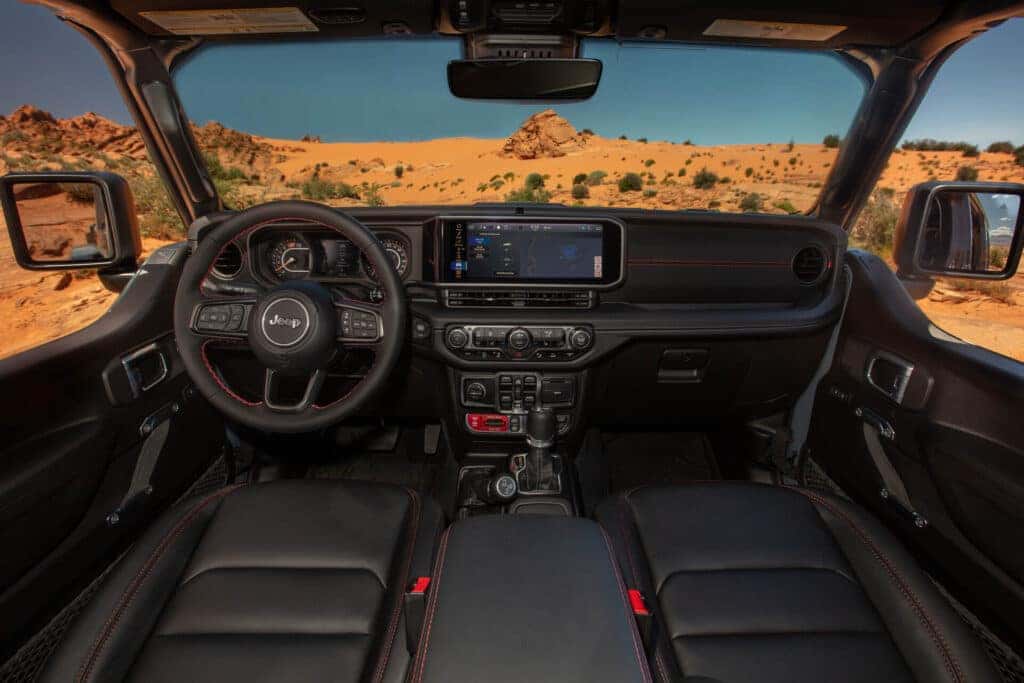 An interior view of the 2025 Jeep Wrangler, black seats and dashboard.