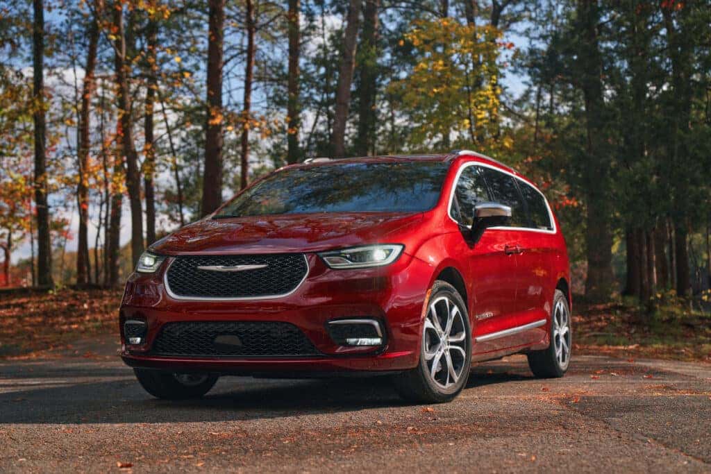A red 2025 Chrysler Pacifica in a forest.