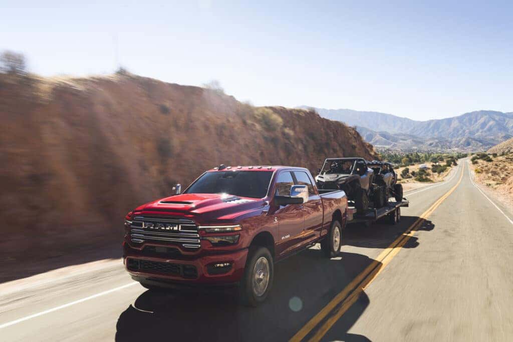 A red 2025 Ram 2500 pulling a trailer.