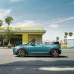 MINI Cooper Convertible parked outside a deli with the top down, near a beach.