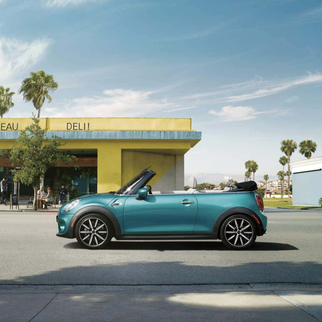 MINI Cooper Convertible parked outside a deli with the top down, near a beach.