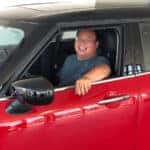 One of our Client Advisors sitting in his brand new red MINI Cooper S.