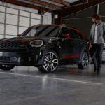 F60 John Cooper Works in a garage with a man walking beside it.
