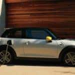 MINI SE being charged at a home by a man.