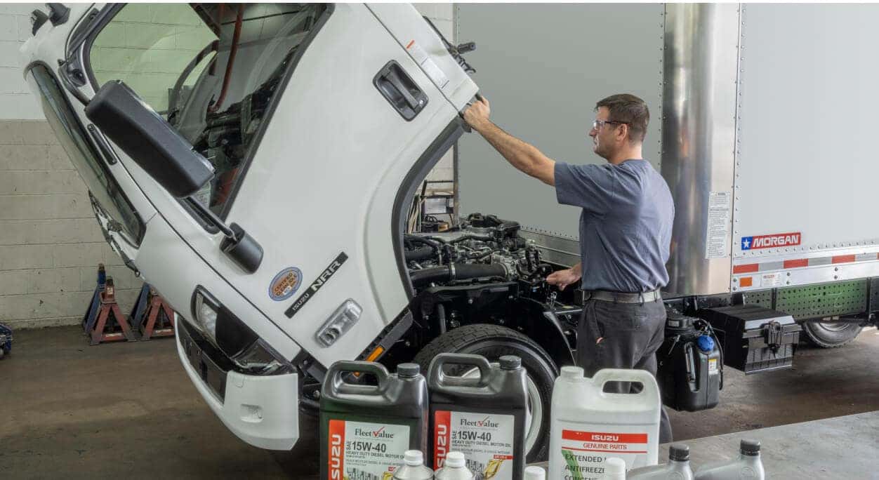 Isuzu NRR Diesel split view showing driver check-in and maintenance in a fleet service setting.