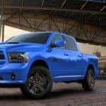 One of the popular blue 1500 Ram Trucks under an overpass at sunset