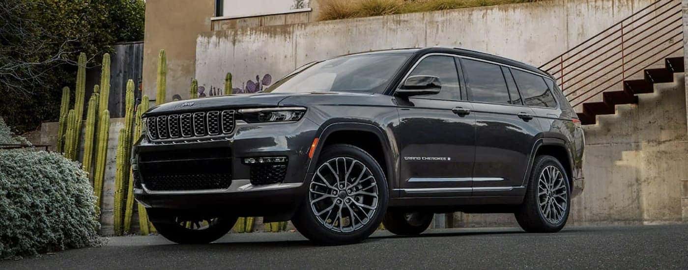 A grey 2022 Jeep Grand Cherokee is shown parked in front of a house.