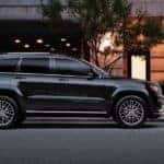 A black Jeep Grand Cherokee from a Jeep Dealership in Los Angeles parked in front of an upscale restaurant at dusk