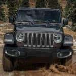 A 2019 Jeep Wrangler is driving in the mud after checking out Jeep lease deals in Costa Mesa, CA.