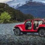 2019 Jeep Wrangler is shown parked on rocks in the woods on a cloudy day. You could find this Jeep for sale near Costa Mesa, CA.