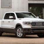 A white 2020 Ram 1500, a popular model among the 2020 Ram trucks, is parked in front of a warehouse near Costa Mesa, CA.