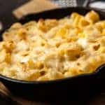Baked Mac N Cheese is shown in a cast iron pan.