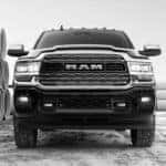 A close up of a black 2020 Ram 2500 is parked next to large cement tubes.