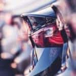 A row of tailgates of used cars for sale are shown.