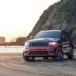 A red 2020 Jeep Grand Cherokee is parked on the beach.