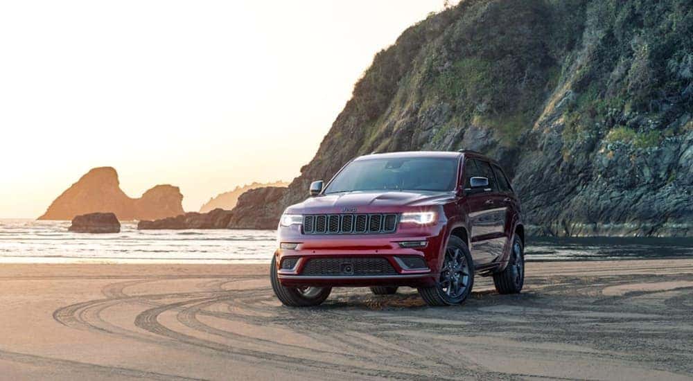 A red 2020 Jeep Grand Cherokee is parked on the beach.