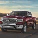One of the popular Ram Trucks in Costa Mesa, a red 2020 Ram 1500, is driving on a highway.