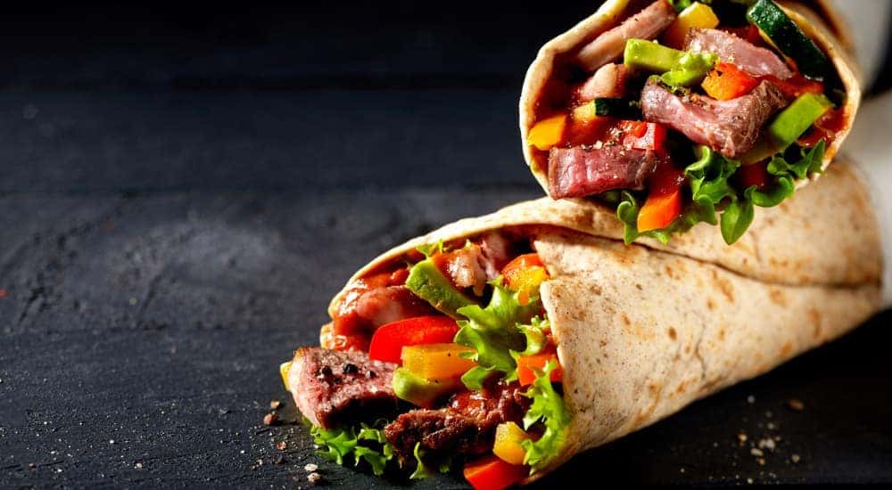 Two burritos are shown on a black background.