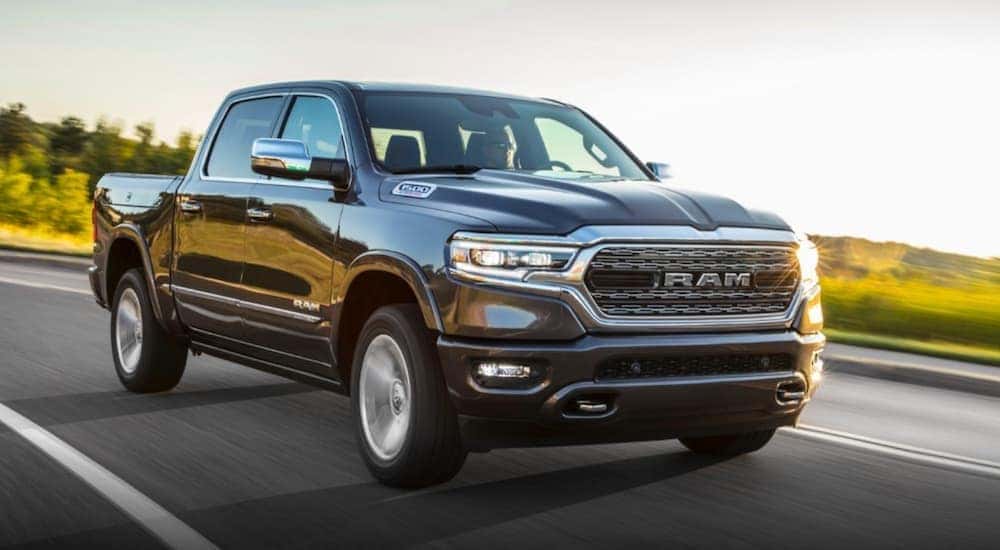 A black 2020 Ram 1500, which is popular among Ram trucks, is driving on a sunny road near Costa Mesa, CA.